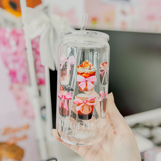 Clear tumbler with cartoon character design held by a hand against a colorful background